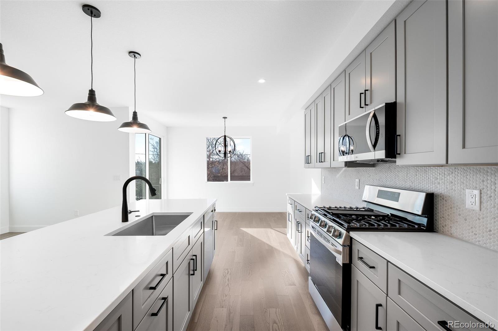 4660 West 9th Avenue Denver, CO 80204 - Photo 8 of 35 a kitchen with stainless steel appliances a sink a stove and a wooden floors