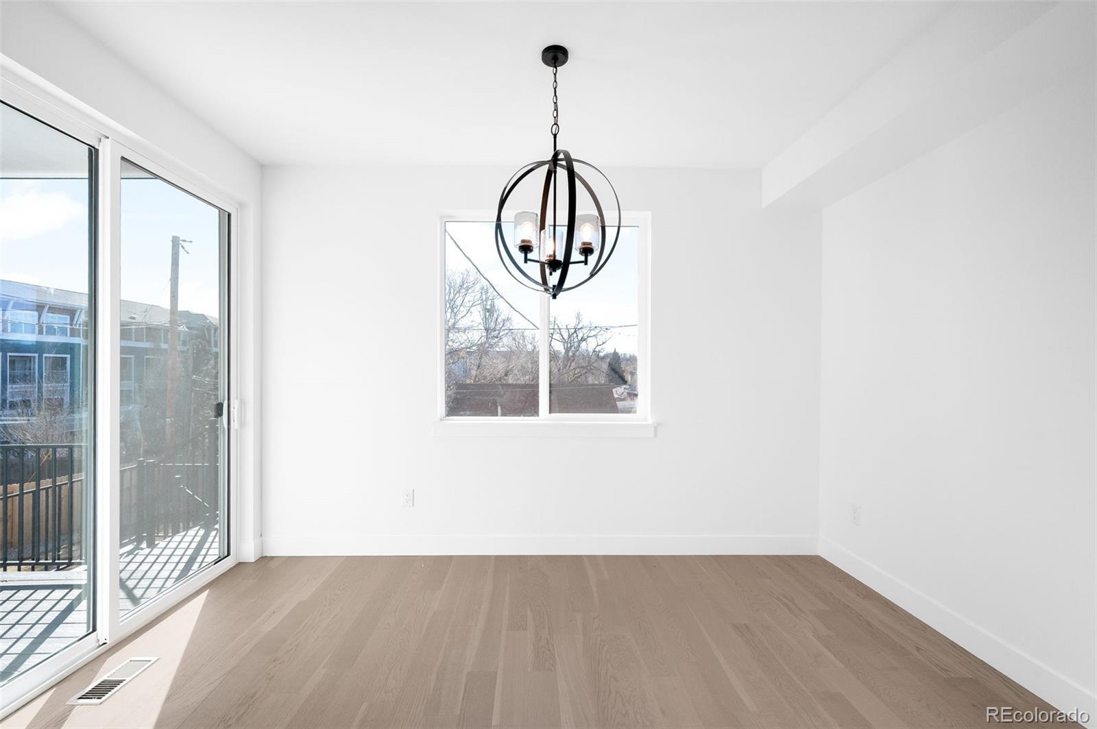 4660 West 9th Avenue Denver, CO 80204 - Photo 9 of 35 a view of a hallway with wooden floor and a chandelier