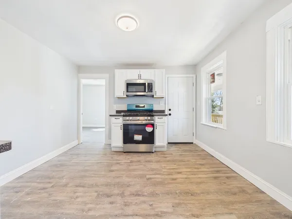 a kitchen with granite countertop a stove a sink and a refrigerator