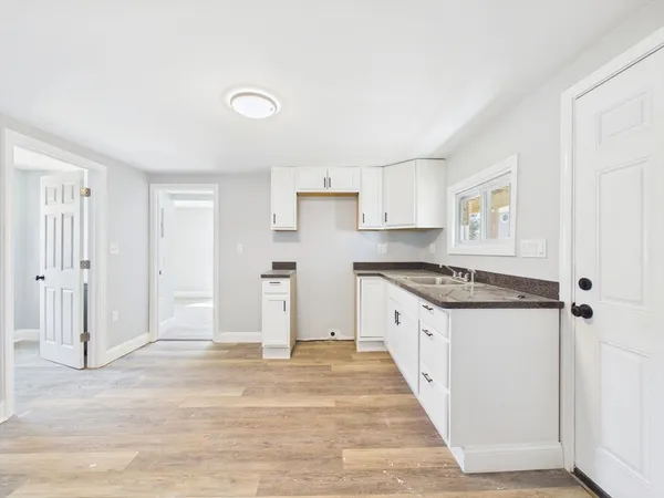 a large kitchen with a stove and white cabinets