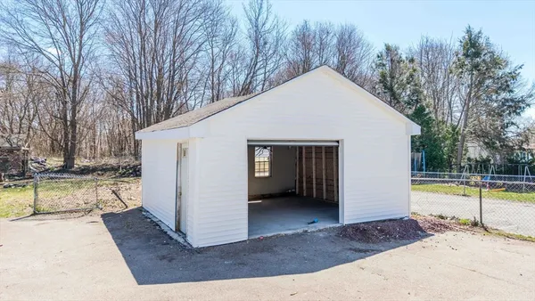 a view of a house with a yard and large tree