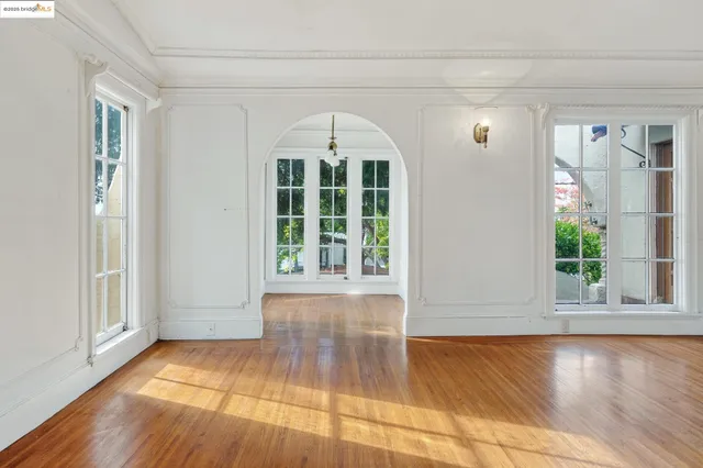 a view of empty room with wooden floor and floor to ceiling window