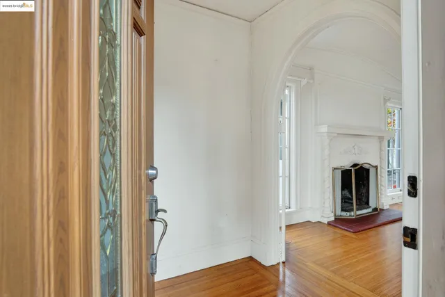 a view of empty room with wooden floor and fireplace