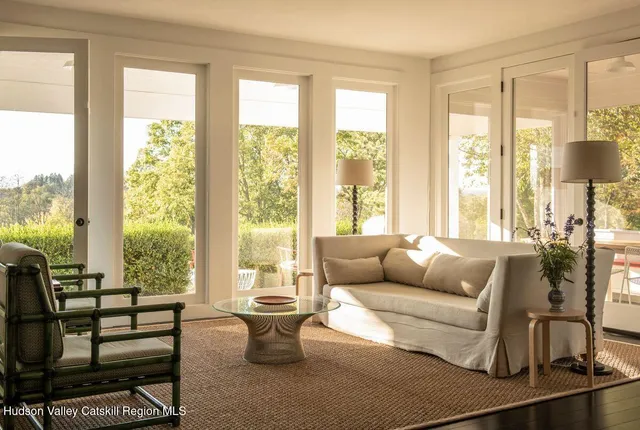 a living room with furniture and a floor to ceiling window