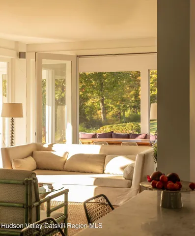 a living room with furniture and a floor to ceiling window