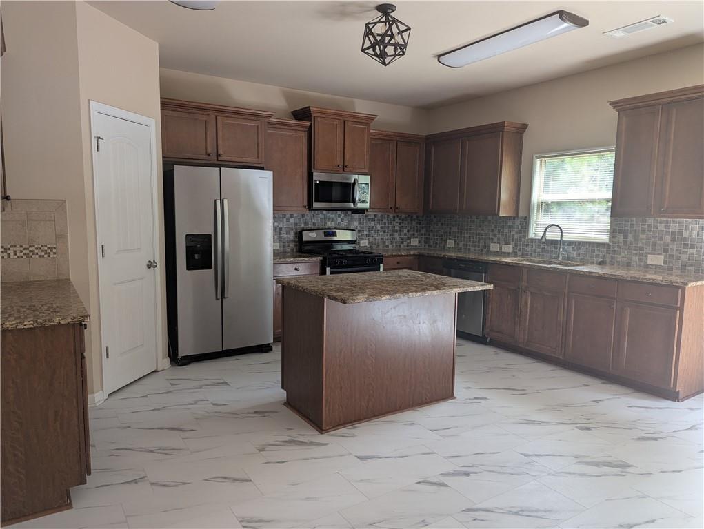 355 Fowler Springs Court Alpharetta, GA 30004 - Photo 3 of 16 a kitchen with stainless steel appliances granite countertop a stove top oven a refrigerator and a sink