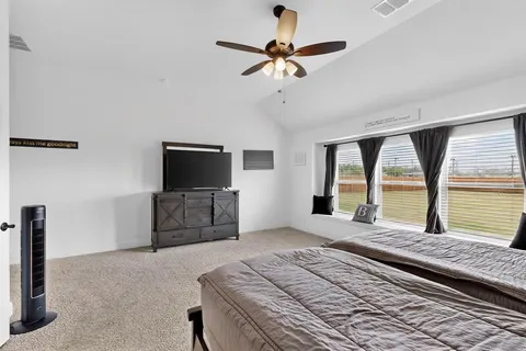 a bedroom with a bed and a large window