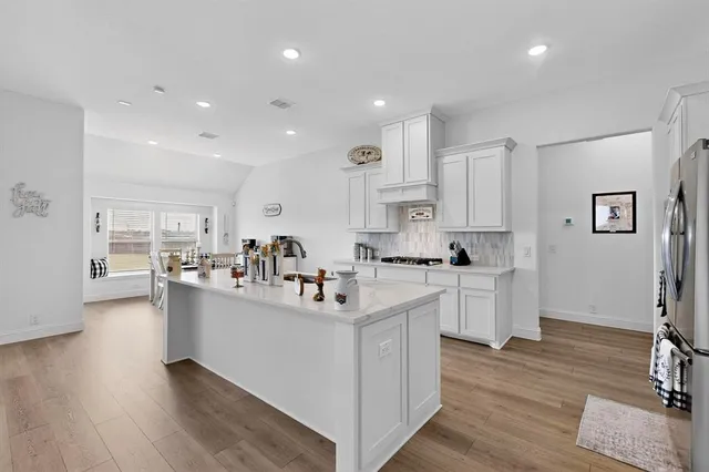 a kitchen with white cabinets and stainless steel appliances