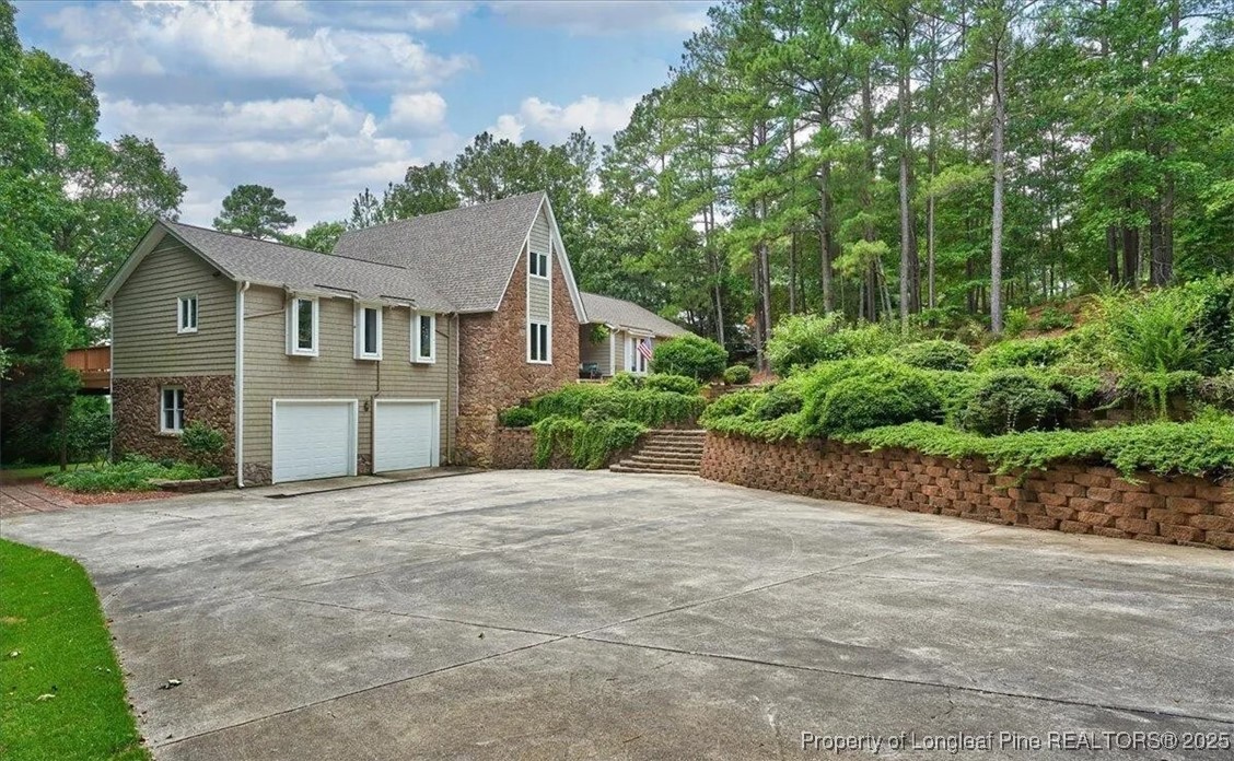 744 Azalea Drive Vass, NC 28394 - Photo 2 of 16 a front view of a house with a garden and trees