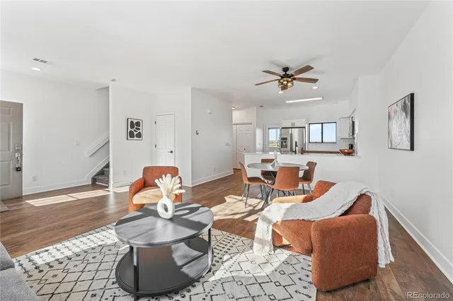 a living room with furniture and wooden floor