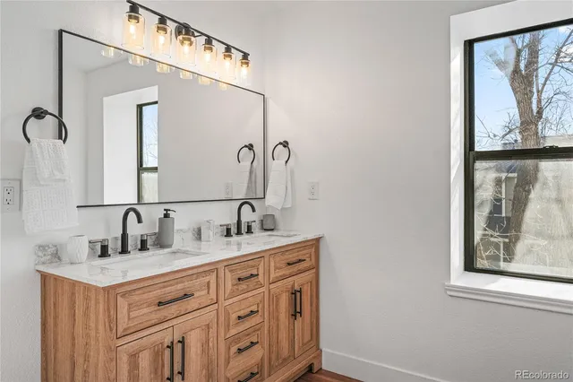 a bathroom with a double vanity sink and a mirror