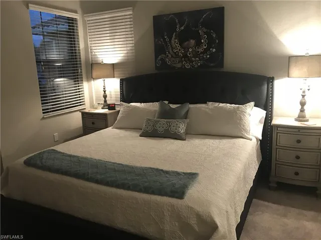 a bedroom with a bed and lamps
