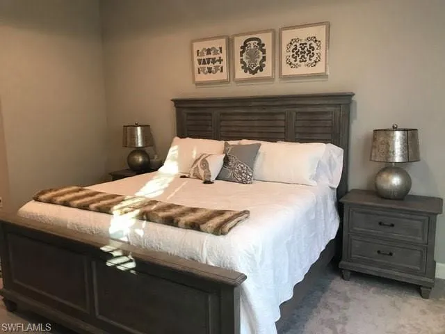 a bedroom with a bed and painting on the wall
