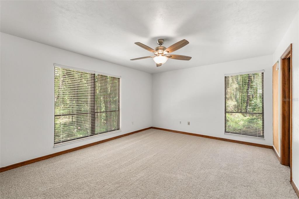 4703 Northwest 124th Street Gainesville, FL 32606 - Photo 36 of 55 an empty room with windows and chandelier fan