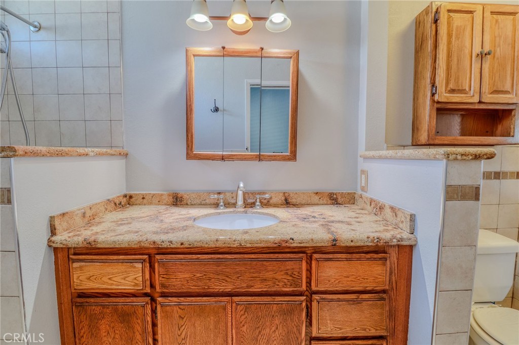 14738 Pioneer Boulevard Norwalk, CA 90650 - Photo 66 of 72 a bathroom with a granite countertop sink and a mirror