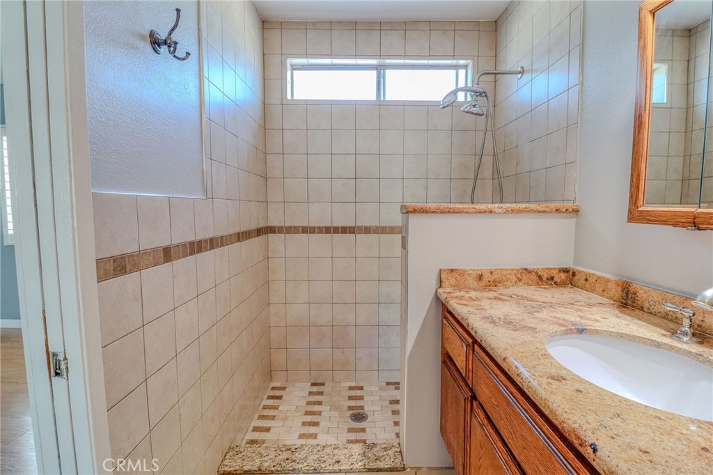 14738 Pioneer Boulevard Norwalk, CA 90650 - Photo 68 of 72 a bathroom with a granite countertop sink a shower and a mirror