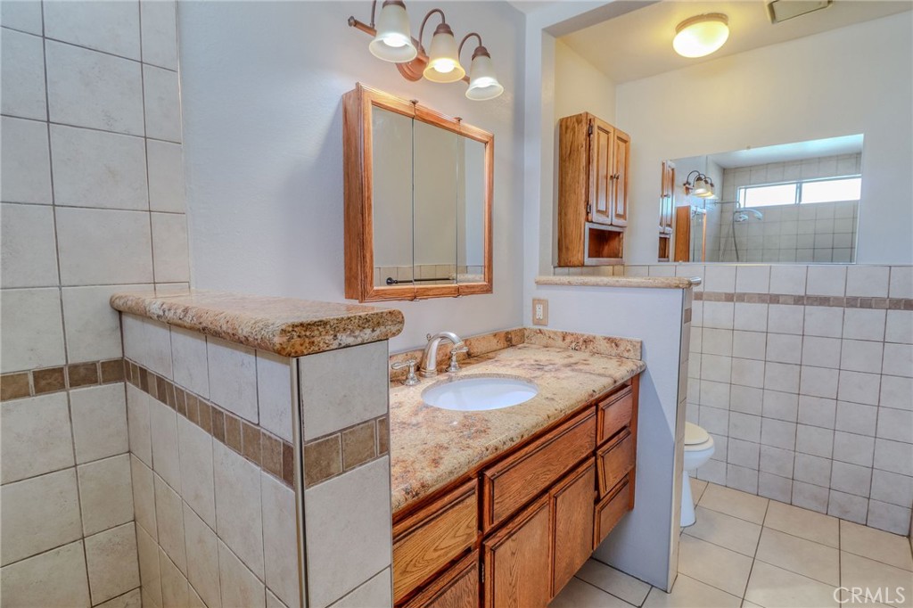 14738 Pioneer Boulevard Norwalk, CA 90650 - Photo 72 of 72 a bathroom with a granite countertop sink and a mirror