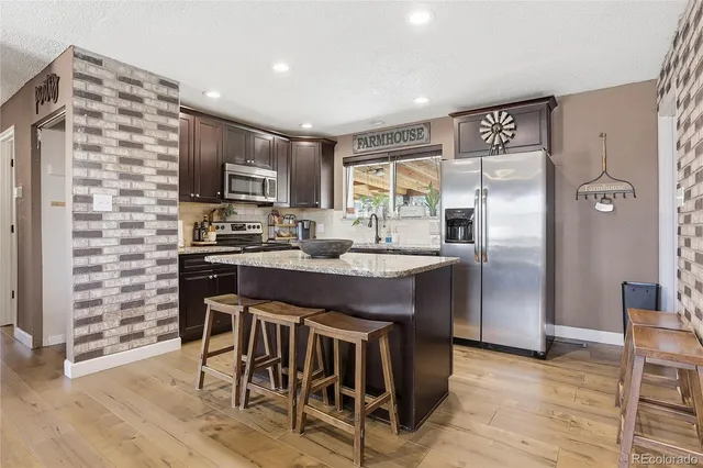 a kitchen with stainless steel appliances granite countertop a refrigerator and a stove top oven