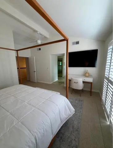 a bedroom with a bed and a flat screen tv