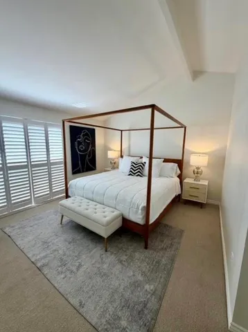 a bedroom with a bed and large window