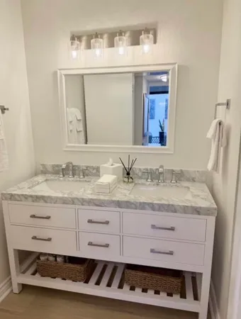 a bathroom with a granite countertop sink and a mirror
