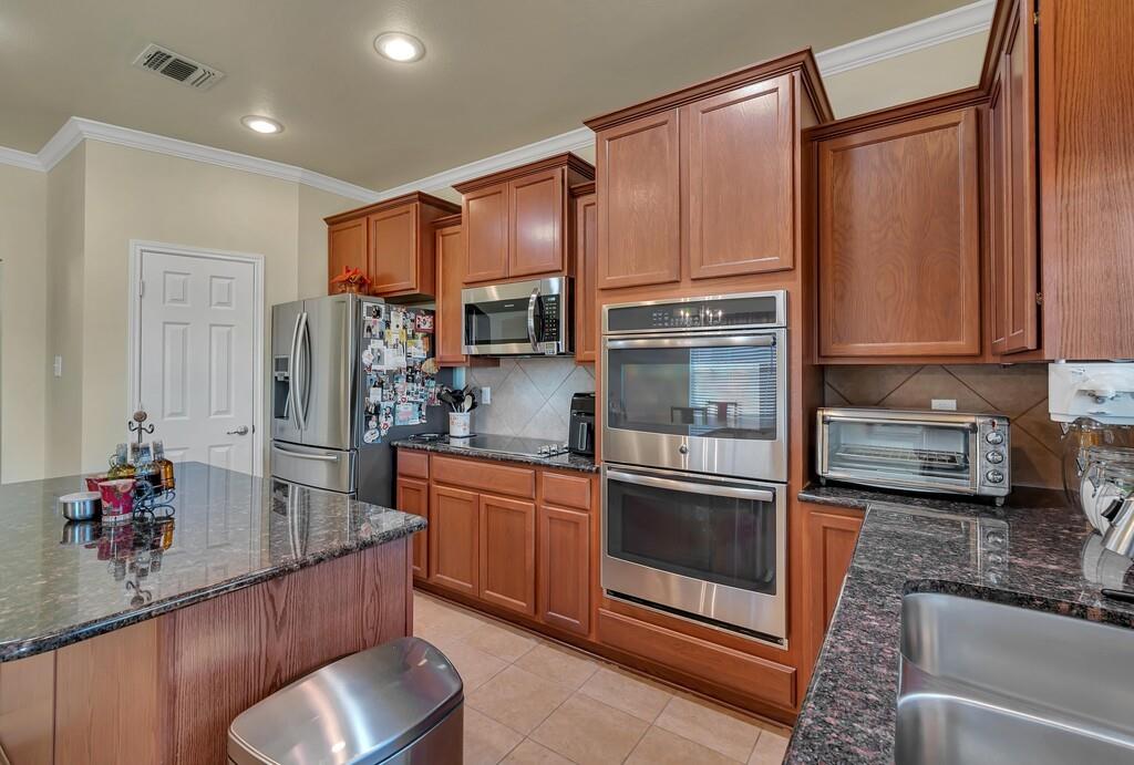 9836 Shallow Creek Drive Waco, TX 76708 - Photo 11 of 32 a kitchen with stainless steel appliances granite countertop a refrigerator and a sink