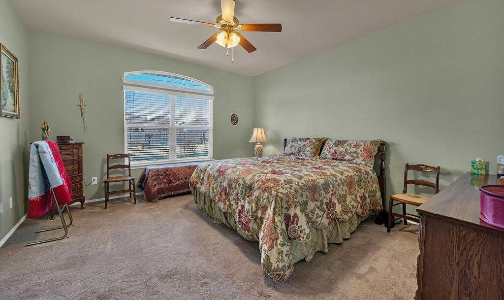 9836 Shallow Creek Drive Waco, TX 76708 - Photo 17 of 32 a bedroom with a bed and a chandelier