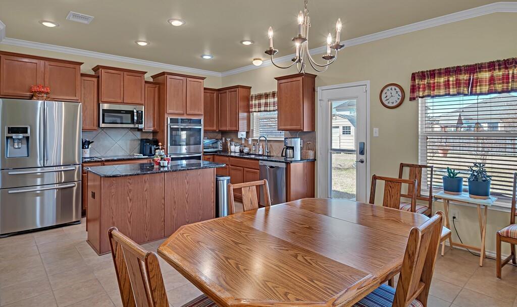 9836 Shallow Creek Drive Waco, TX 76708 - Photo 9 of 32 a kitchen with stainless steel appliances granite countertop a kitchen island a stove a table and chairs
