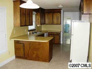 2203 Mills Harris Road Wingate, NC 28174 - Photo 4 of 8 a kitchen with a sink and a refrigerator