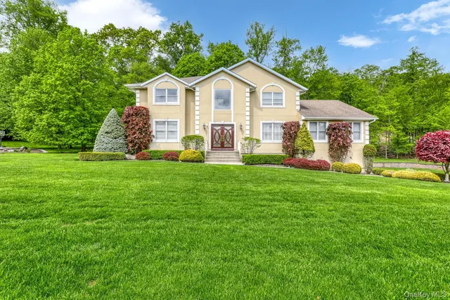 a front view of a house with a yard and trees