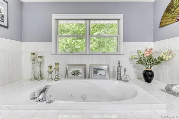 a white bath tub sitting in a bathroom next to a window