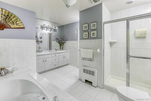 a spacious bathroom with a tub sink and a mirror