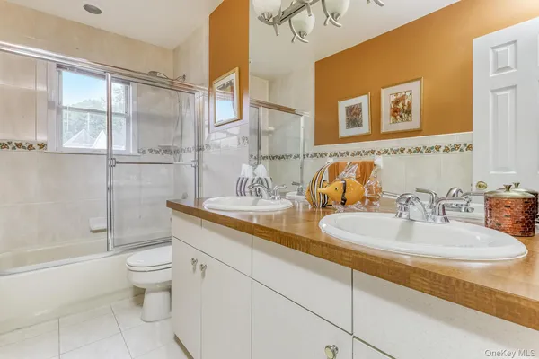 a bathroom with a double vanity sink toilet and shower