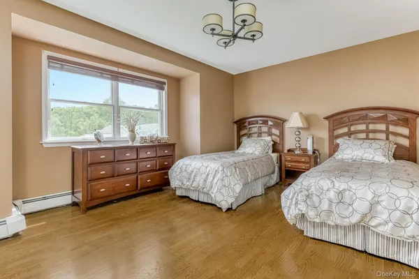 a bedroom with two bed and a window