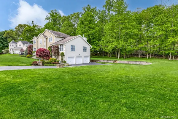 a front view of a house with a yard and trees