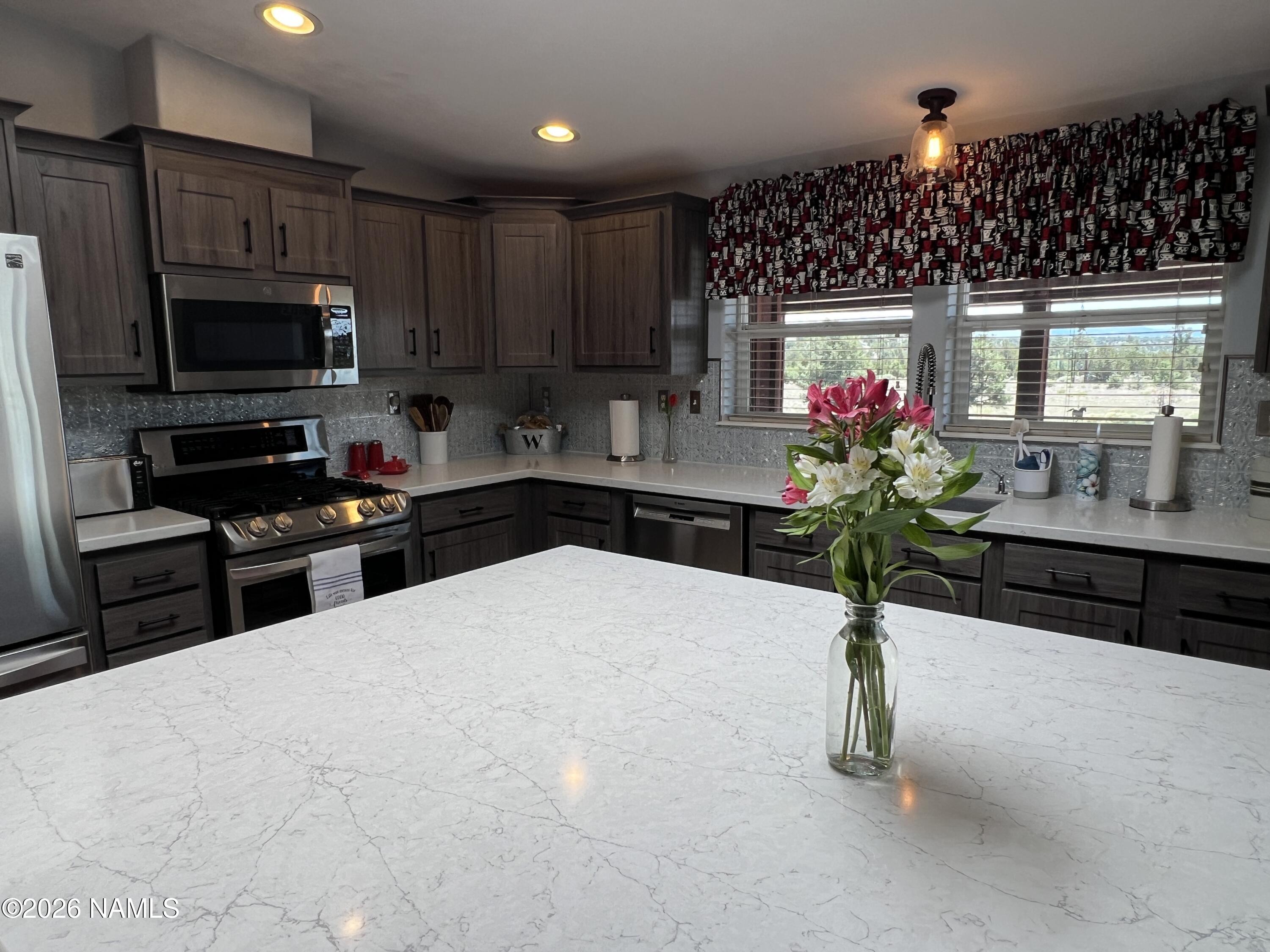 8348 Red Butte Road Williams, AZ 86046 - Photo 72 of 89 a kitchen with granite countertop a stove a sink and a microwave