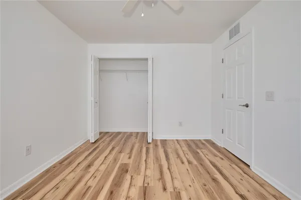 a view of a room with wooden floor and fan