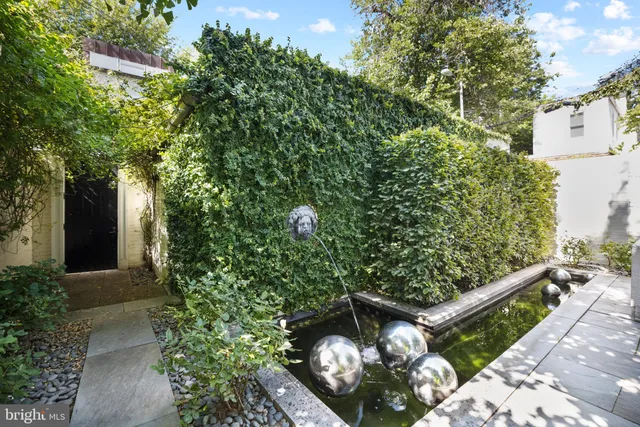 a view of a wooden house with a flower garden