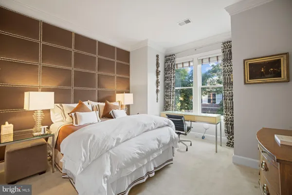 a bedroom with a bed a table and windows