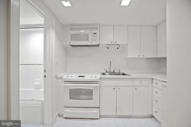a kitchen with white cabinets and a sink