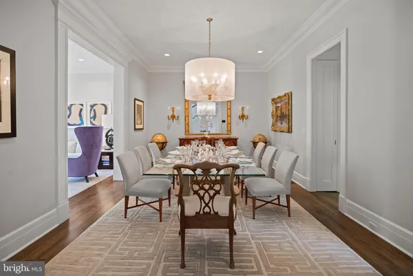 a dining room with wooden floor a glass table and chairs
