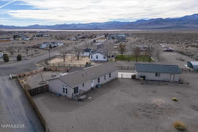 an aerial view of a house with a mountain