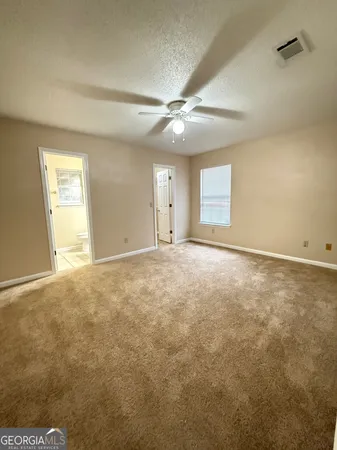 an empty room with an entryway and fan