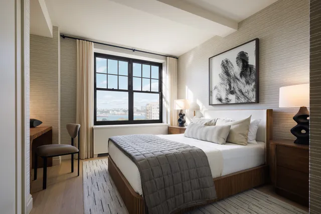 a bedroom with a bed and a painting on the wall