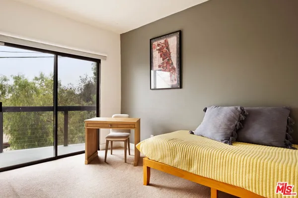 a bedroom with a bed and painting on the wall