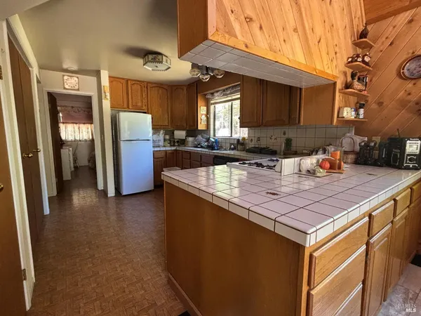 a kitchen with stainless steel appliances granite countertop a sink a stove a refrigerator a washer and dryer