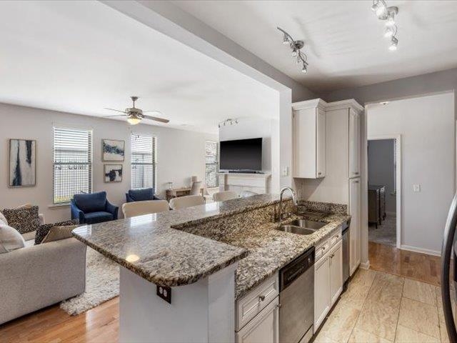 580 South Main Street, Unit 204 Memphis, TN 38103 - Photo 26 of 28 Kitchen featuring open floor plan, dark stone counters, dishwasher, and a peninsula
