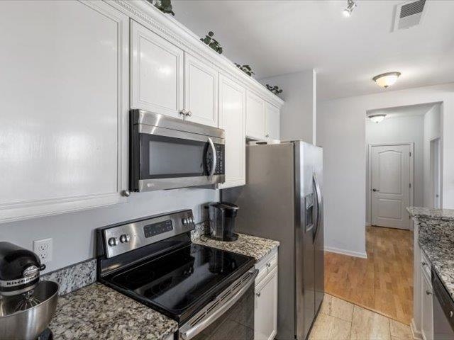 580 South Main Street, Unit 204 Memphis, TN 38103 - Photo 8 of 28 Kitchen with stainless steel appliances, light stone countertops, and white cabinets