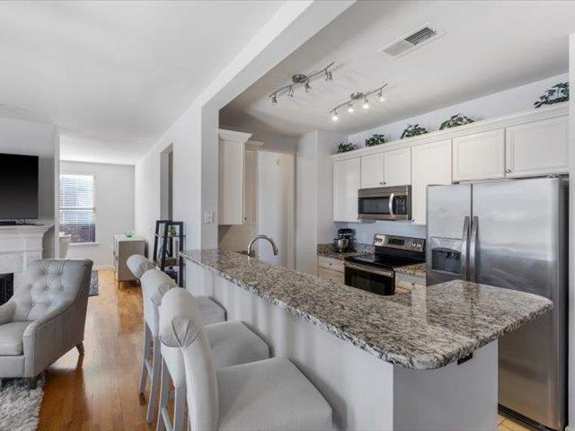 580 South Main Street, Unit 204 Memphis, TN 38103 - Photo 27 of 28 Kitchen with stainless steel appliances, a breakfast bar area, a peninsula, dark stone countertops, and open floor plan