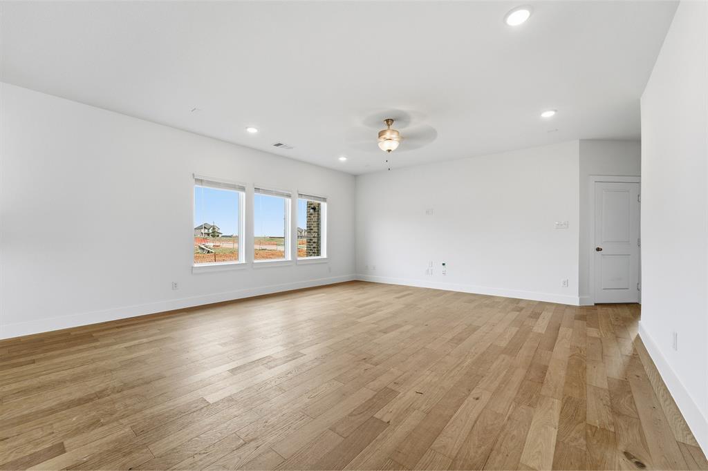 225 Charismatic Road Waxahachie, TX 75165 - Photo 13 of 21 a view of an empty room with wooden floor and a window